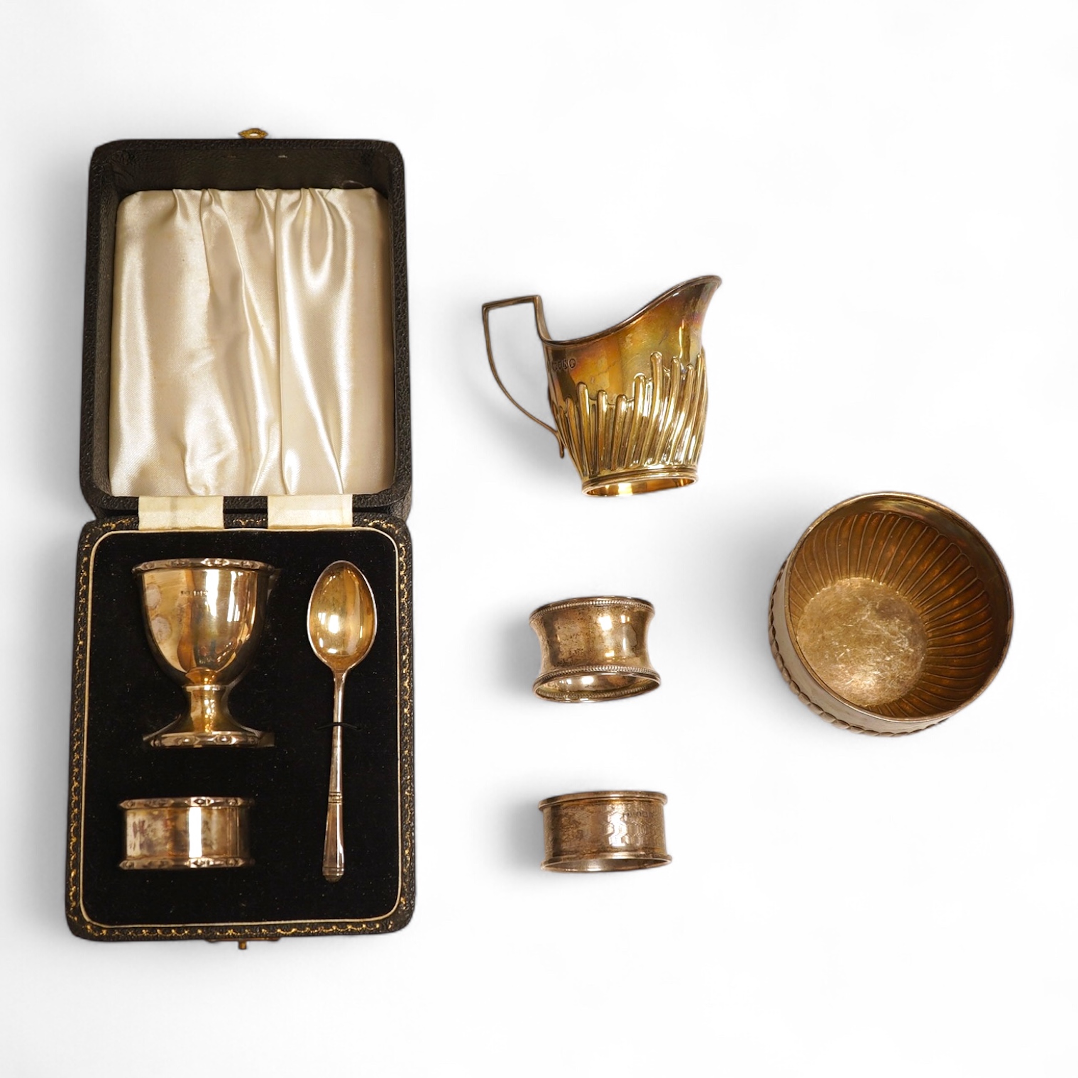A late Victorian demi-fluted cream jug and sugar bowl, Charles Stuart Harris, London, 1888, together with cased silver christening egg cup, spoon and napkin ring and two other silver napkin rings.